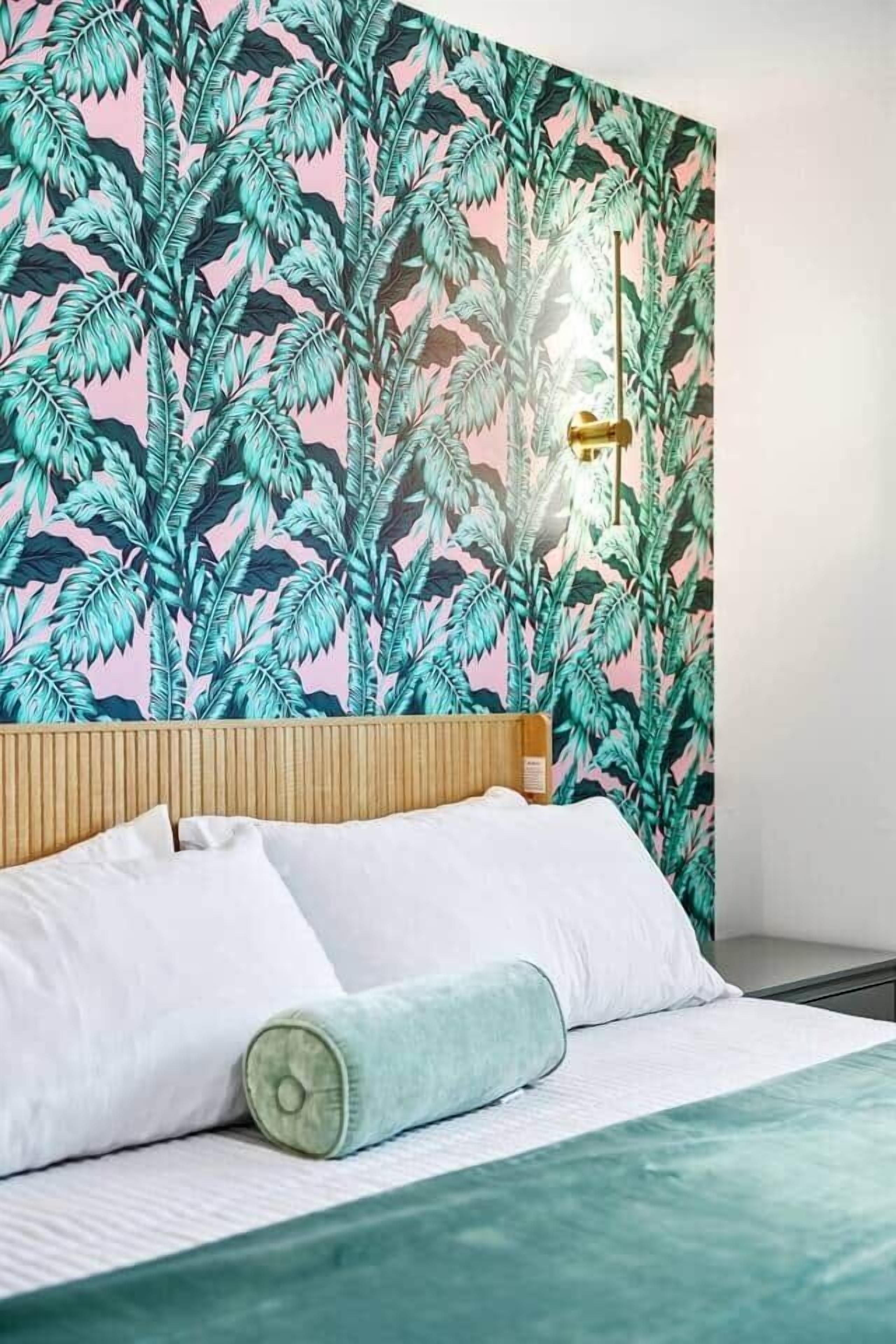 A bedroom with a bed, pillows, and a headboard.