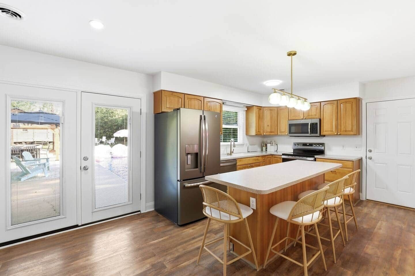 A modern kitchen with a central island, stainless steel appliances, and wooden cabinetry.