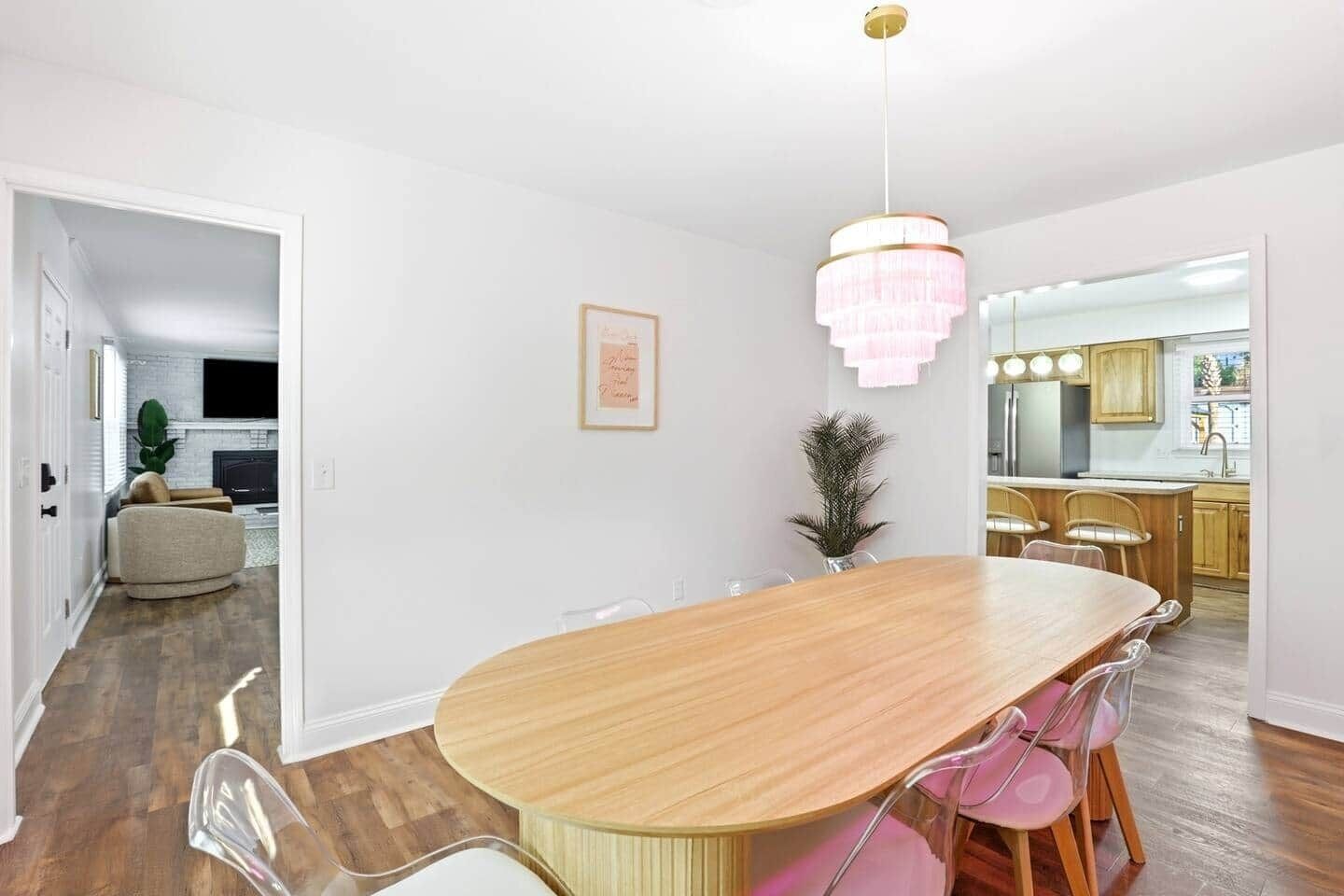 Un vaste espace dédié à la salle à manger, avec une grande table ovale, des chaises modernes et un lustre.