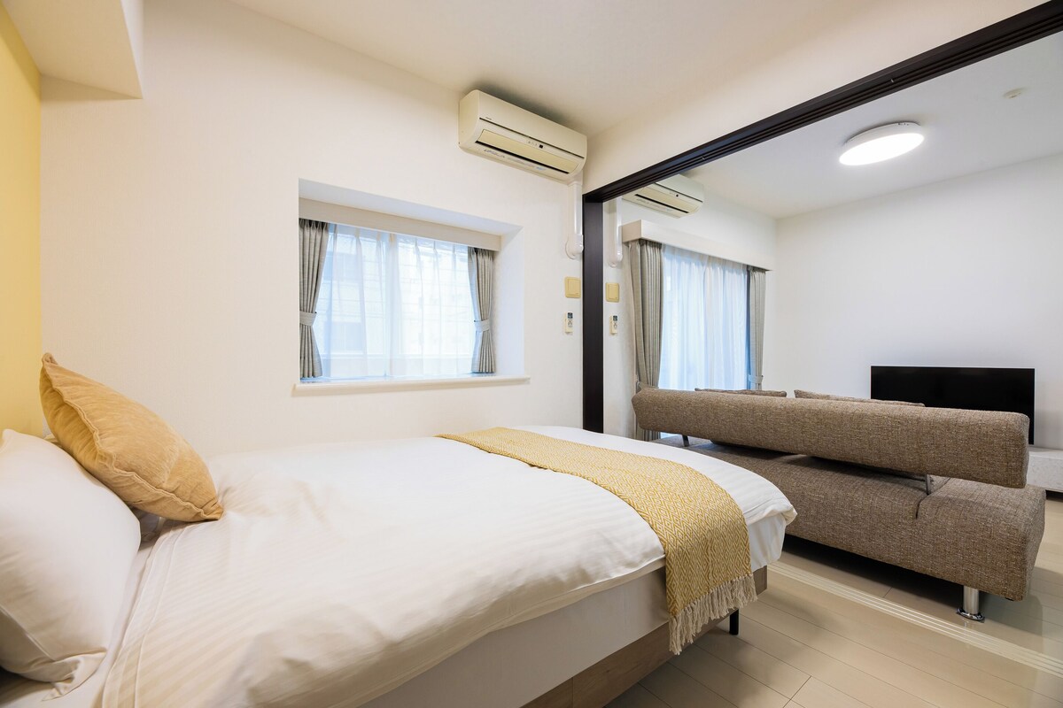 Ein Hotelzimmer mit einem Bett, einer Couch, einem Fernseher und einer Klimaanlage.