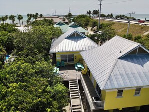 A coastal property with multiple buildings, a dock, and a view of the ocean. - Heart of the Key Cottage (Marathon)