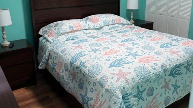A bedroom with a bed, nightstands, a lamp, a window with blinds, and a wardrobe. - Heart of the Key Cottage (Marathon)