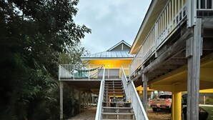 A staircase leading to a building with a yellow facade and a balcony. - Heart of the Key Cottage (Marathon)