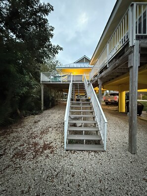 A staircase leading to a building with a yellow facade and a balcony. - Heart of the Key Cottage (Marathon)