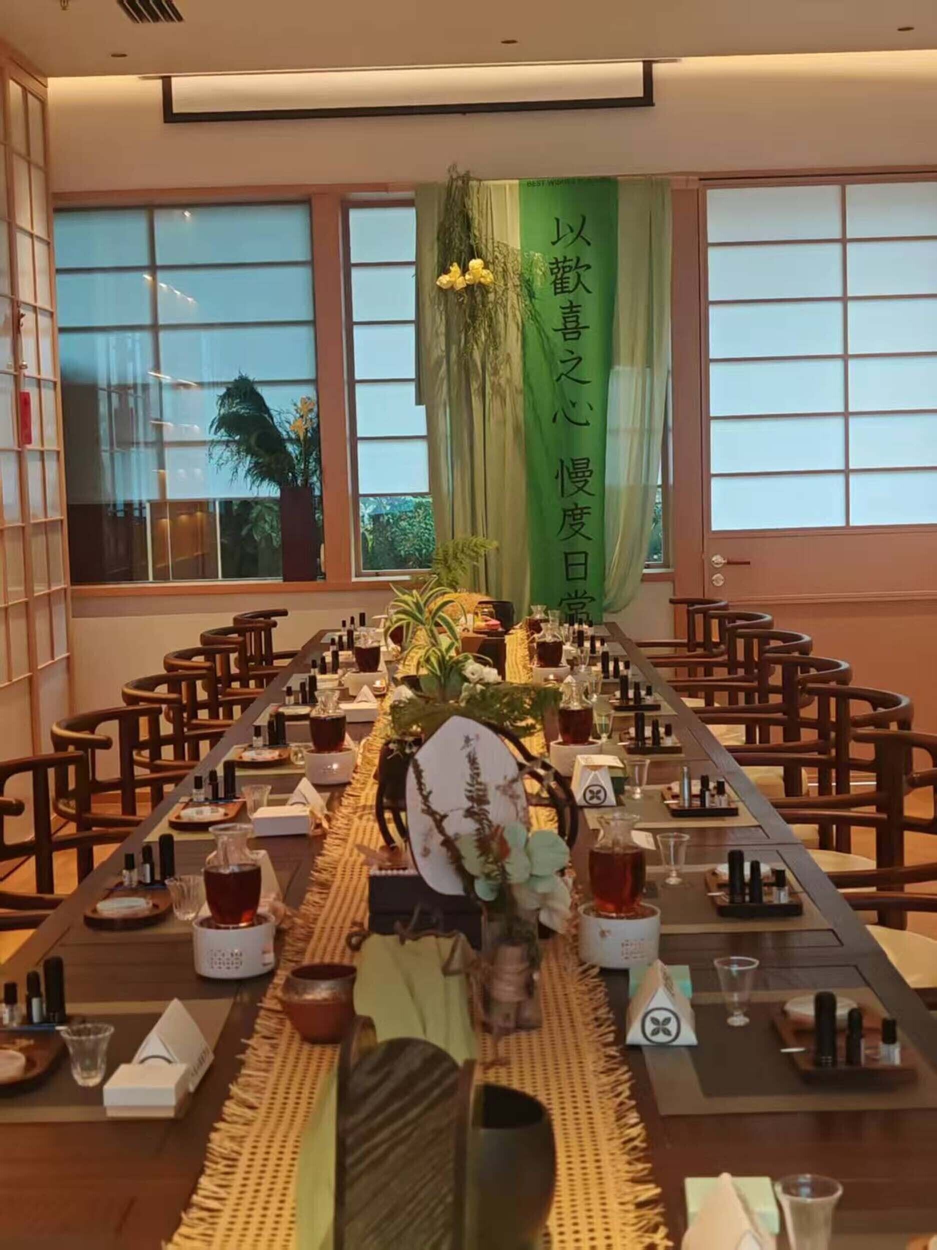 A conference room with a long table set for a meeting, surrounded by chairs.