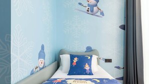 A bedroom with a bed, pillows, and a wall with snowflake patterns.