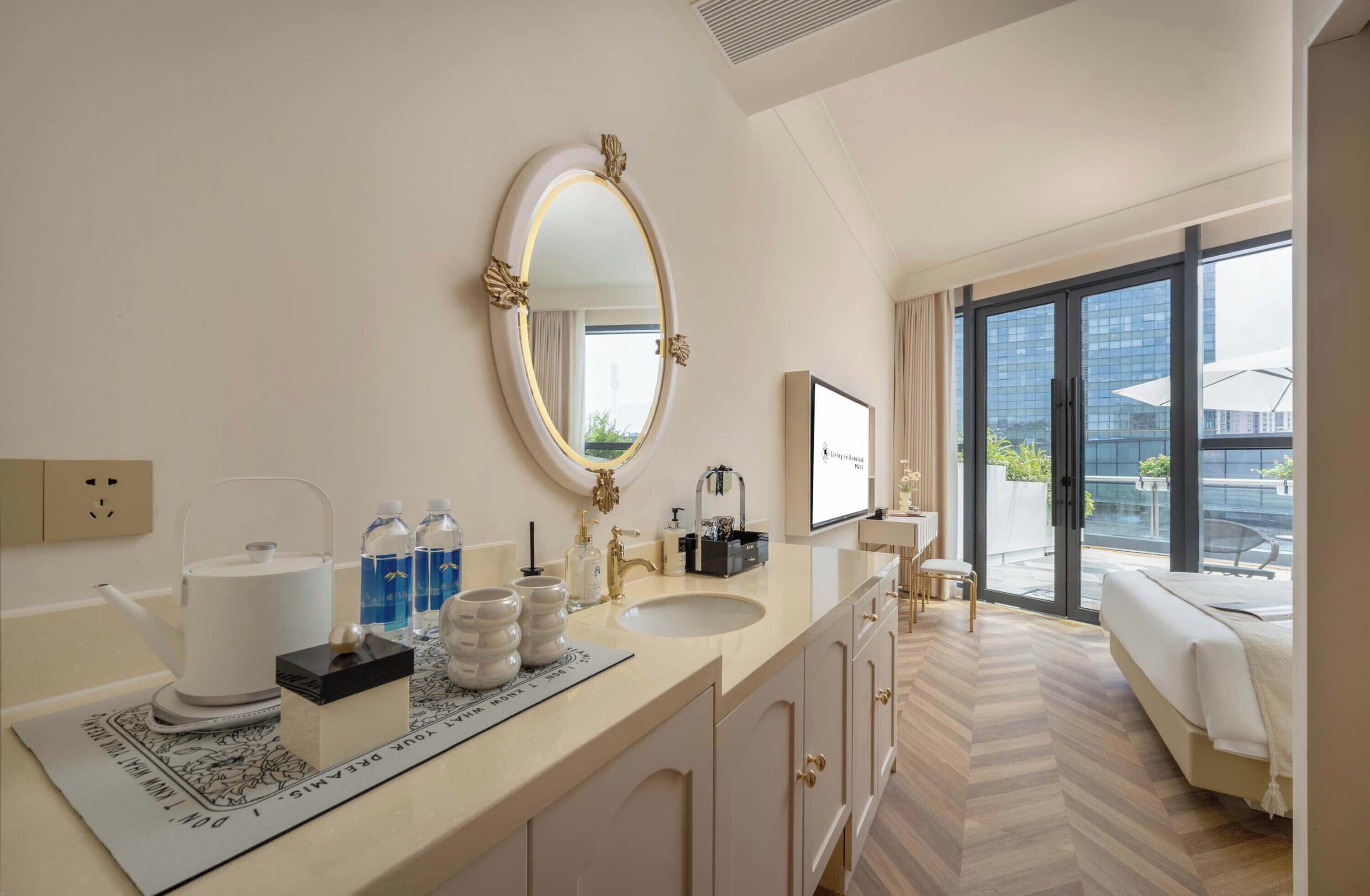 Ein modernes Hotelbad mit einem großen Spiegel, einem Waschbecken, einer Toilette und einem Duschbereich.