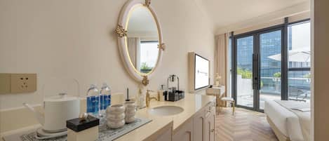 A modern hotel bathroom with a large mirror, a sink, a toilet, and a shower area.