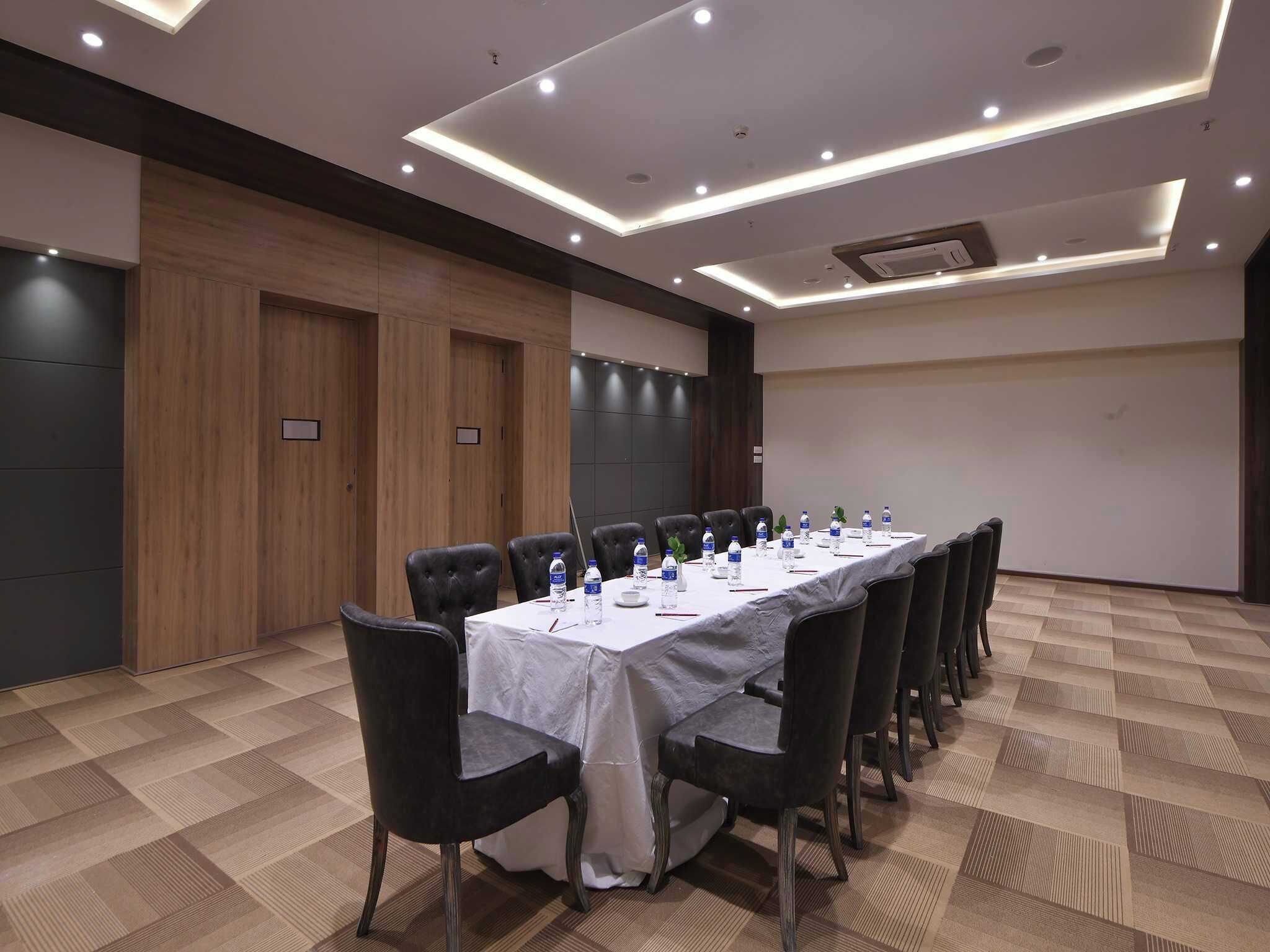 A conference room with a long table, chairs, and water bottles.