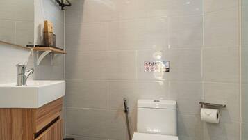 A modern bathroom with a toilet, sink, and shower.