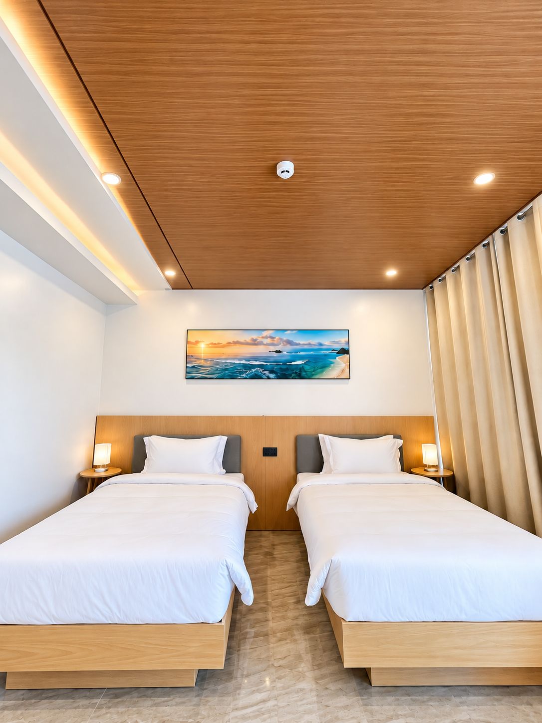 Camera d'albergo con due letti, soffitto in legno, un quadro raffigurante un tramonto e vista sul mare.