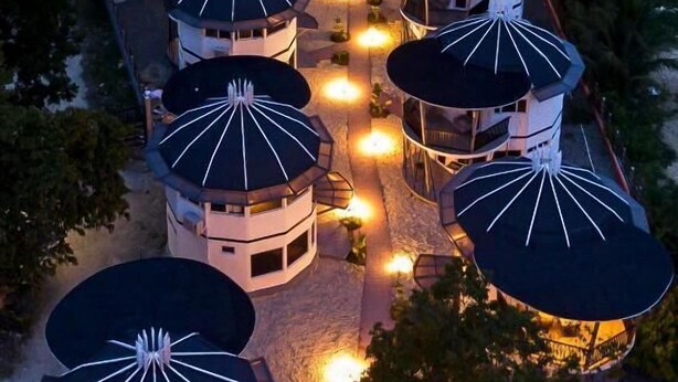 A circular building with multiple domed structures, surrounded by trees and a central tower. - Fizz Diving Resort (Panglao)