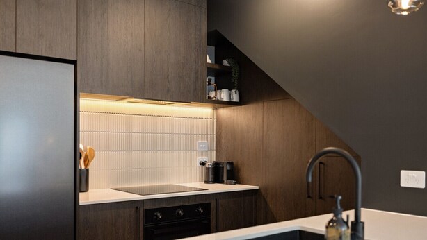 A modern kitchen with a built-in dishwasher, a stainless steel sink, and a sleek countertop. - Prime Location with mountain views (Queenstown)