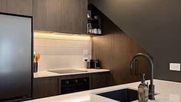 A modern kitchen with a built-in dishwasher, a stainless steel sink, and a sleek countertop.