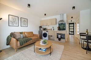 A modern apartment with a living room, kitchen, and dining area. - Lake and Mountain Views (Queenstown)