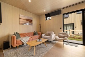 A modern living room with a sofa, armchair, and a coffee table. - Modern Queenstown 2Bed Villa (Queenstown)