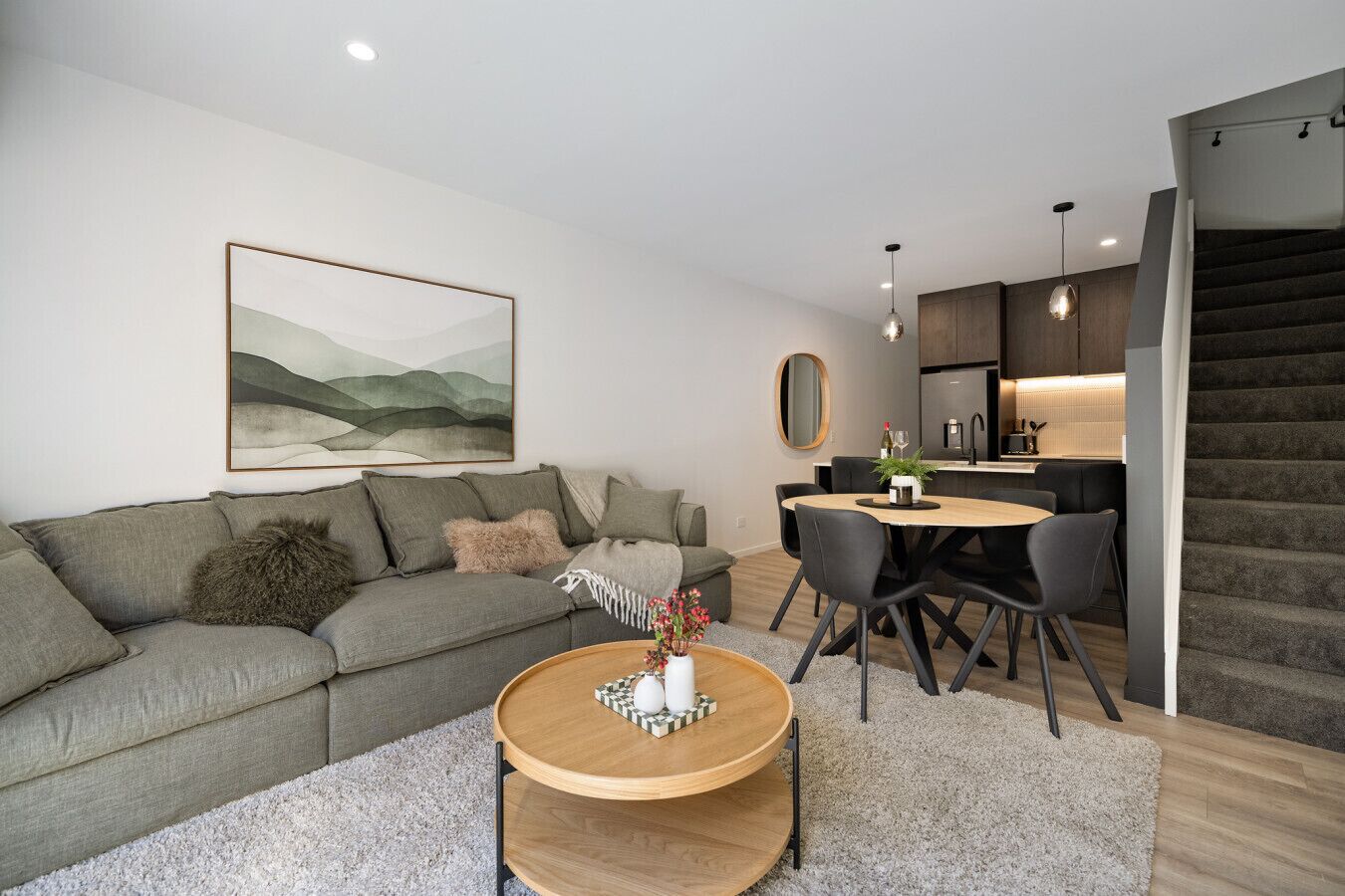 Una sala moderna con sofá, mesa de centro y comedor.