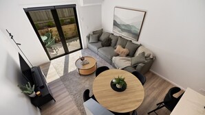 A modern living room with a sofa, a round wooden coffee table, and a dining area with chairs. - Prime Location with mountain views (Queenstown)
