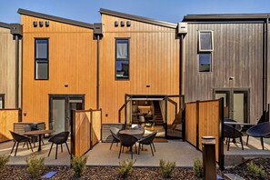 A modern building with wooden paneling, outdoor seating, and a staircase leading to an upper level. - Prime Location with mountain views (Queenstown)