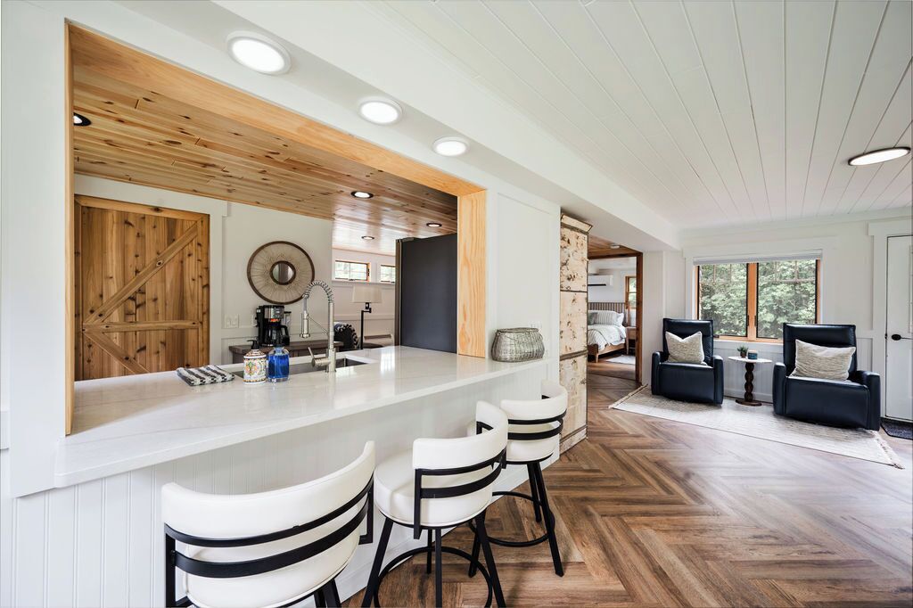 Una cocina moderna con barra, detalles de madera y un patrón de suelo en espiga.