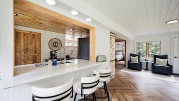 Una cocina moderna con barra, detalles de madera y un patrón de suelo en espiga.