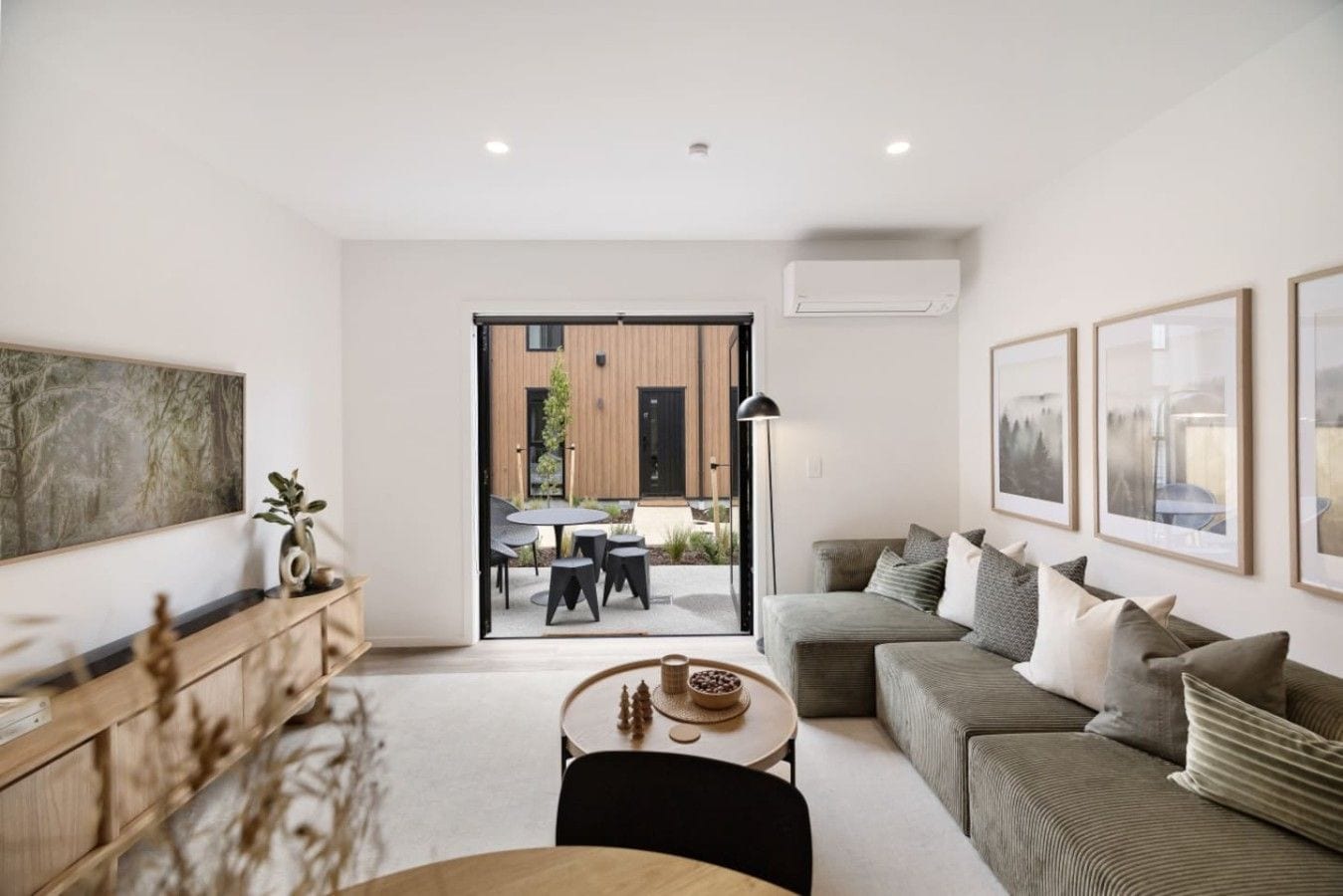 A modern living room with a sofa, coffee table, and artwork on the walls.