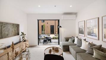 A modern living room with a sofa, coffee table, and artwork on the walls.