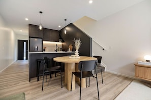 A modern kitchen with a central island, dark cabinetry, and pendant lighting. - Prime Location with mountain views (Queenstown)