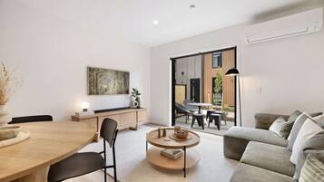 Un salon moderne comprenant un coin repas, un canapé, une table basse et une vue sur l’extérieur.