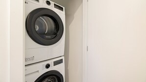A stacked washer and dryer unit in a laundry room. - Prime Location with mountain views (Queenstown)