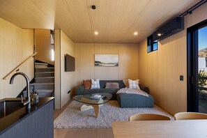 A modern interior with a staircase, a sofa set, a glass coffee table, and a view through a large window. - Prime Location Luxury Villa (Queenstown)