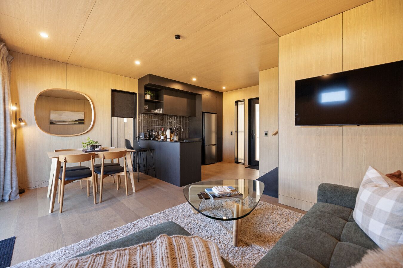 A modern living room with a sofa, coffee table, and dining area with chairs.