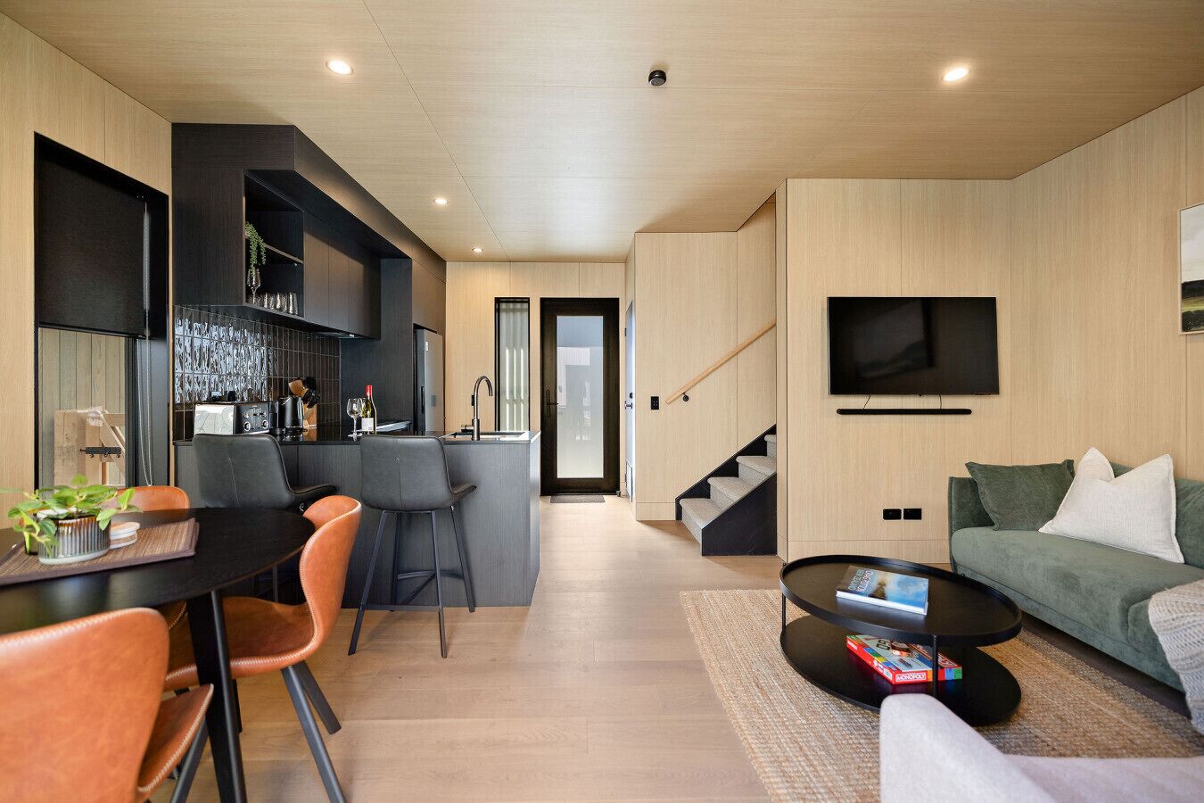 A modern living space with a kitchen, dining area, and a sofa.