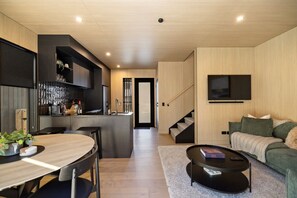 A modern interior with a kitchen, dining area, and living space. - Luxury Queenstown 2Bed Villa (Queenstown)