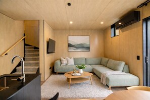 Ein modernes Wohnzimmer mit einer Couch, einem Couchtisch und einem Gemälde an der Wand.