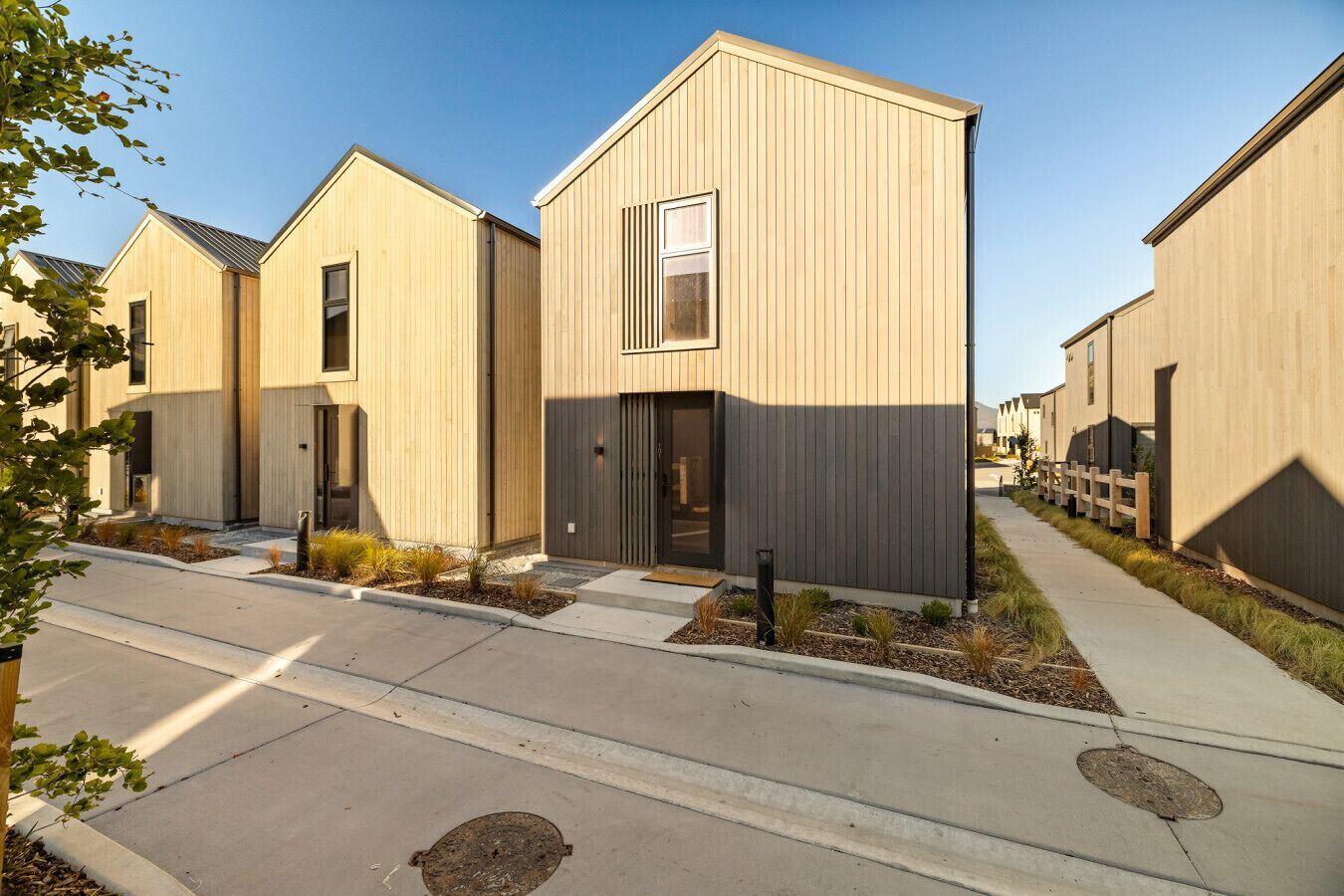 A row of modern, single-story buildings with a uniform design, featuring large windows and a flat roof.