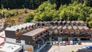 Et hotel med flere etager, parkeringsplads og en række balkoner.