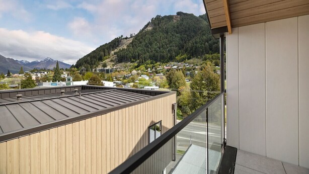 A modern building with a wooden facade and a balcony overlooking a town and mountains. - Prime Location, Walk to town, Queenstown (Queenstown)
