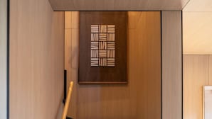 Ein modernes Interieur mit einer Holzvertäfelung und einem geometrischen Kunstwerk.
