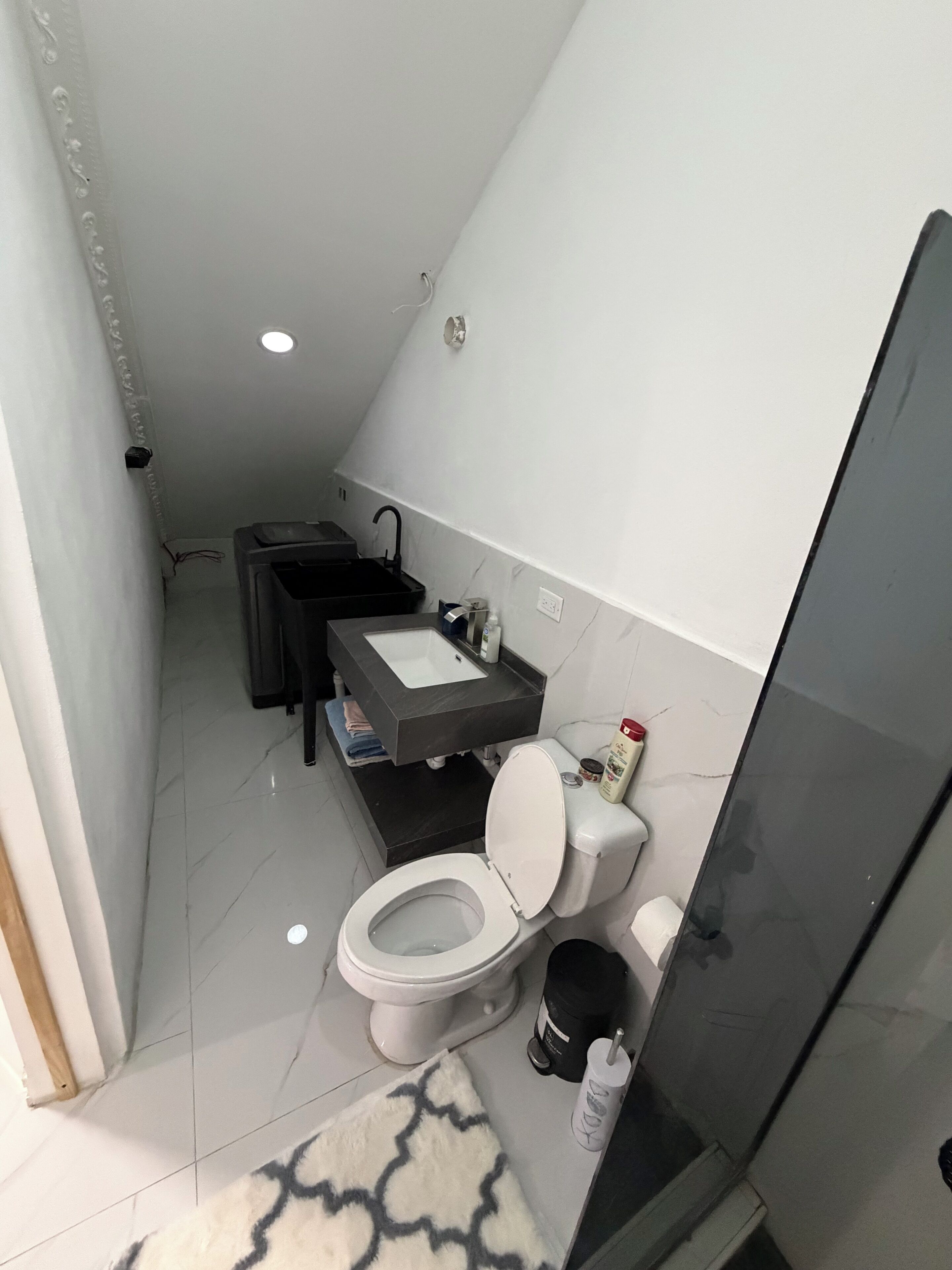Ein kleines Badezimmer mit Toilette, Waschbecken und Duschbereich.