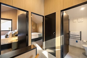 Een moderne hotelkamer met een bed, een bureau, een badkamer met toilet en douche.