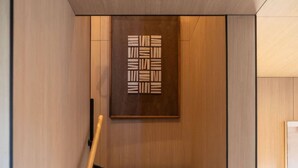 Un intérieur moderne avec un mur en bois et une œuvre d’art abstraite encadrée.