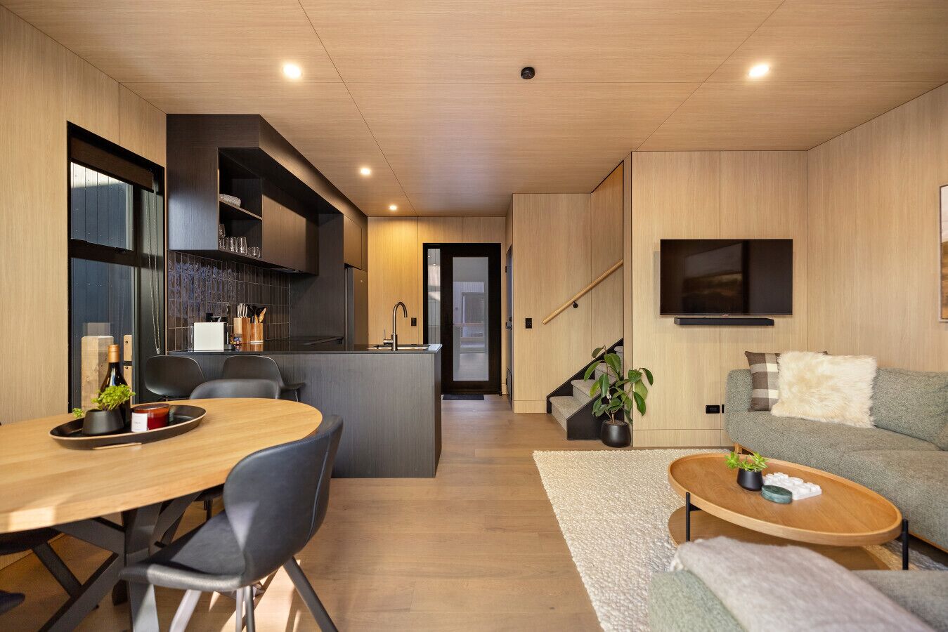 Un espace de vie moderne comprenant une cuisine, un coin repas et un coin salon confortable.