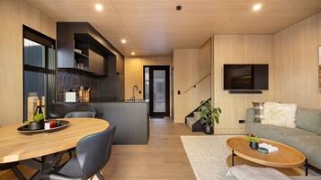 Un espace de vie moderne comprenant une cuisine, un coin repas et un coin salon confortable.