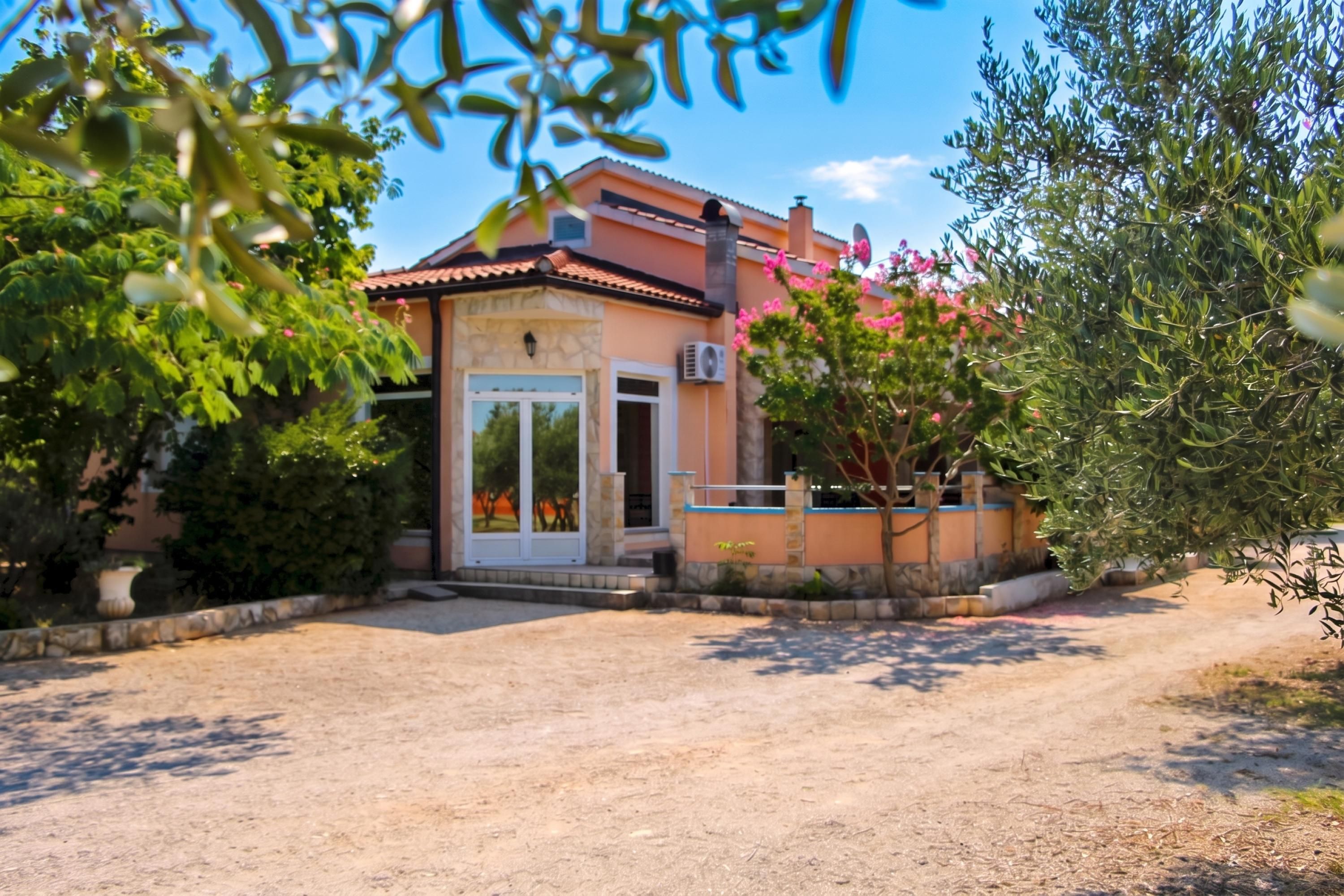 Una casa a un piano con tetto in tegole, una porta d'ingresso e un piccolo portico.
