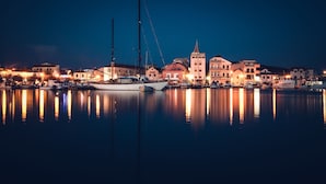 Een haven bij nacht met aangemeerde boten en gebouwen langs de waterkant.
