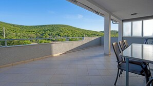 A balcony with a table and chairs, a view of green hills, and a clear sky. - Pool Villa Marija, Šibenik, Croatia (Šibenik)