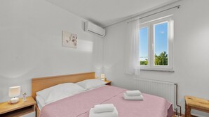 A bedroom with a bed, bedside tables, a window, and an air conditioning unit. - Pool Villa Marija, Šibenik, Croatia (Šibenik)