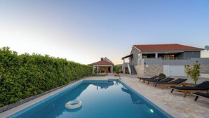 A swimming pool with lounge chairs, a small building, and a hedge. - Pool Villa Marija, Šibenik, Croatia (Šibenik)