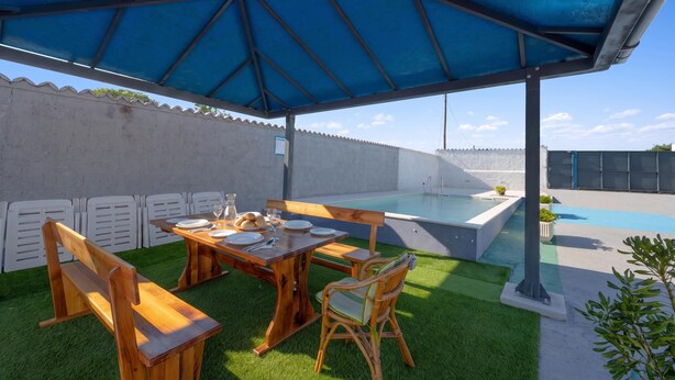 An outdoor patio with a wooden table, chairs, and a blue umbrella. - Holiday Home Eros with Pool, Šibenik, Croatia (Šibenik)